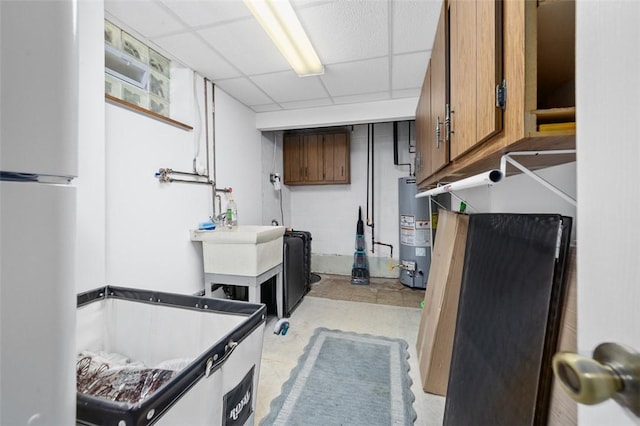 9204 Douglas Fir Dr, Plum Boro, PA 15239 - below grade area with gas water heater, freestanding refrigerator, a paneled ceiling, and a sink