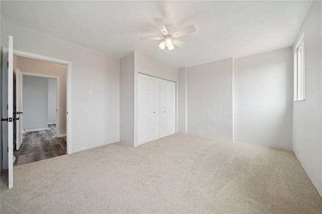 unfurnished bedroom with carpet, a closet, and a ceiling fan