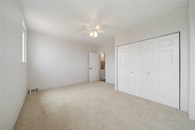 unfurnished bedroom featuring carpet flooring, a closet, and ceiling fan