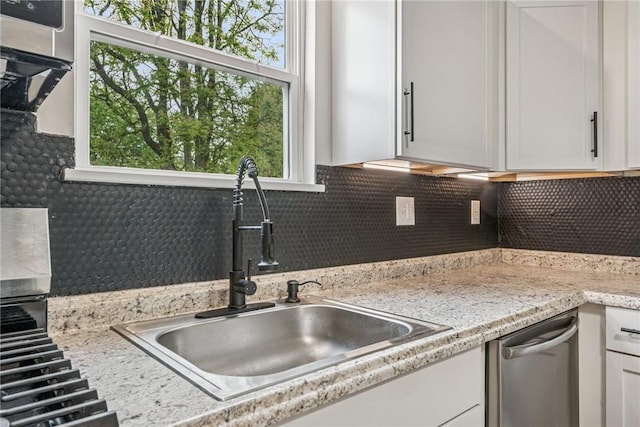 412 Mary St, Latrobe, PA 15650 - kitchen featuring a sink, backsplash, white cabinets, and stainless steel dishwasher