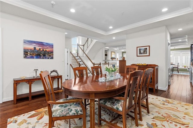 dining room featuring hardwood / wood-style flooring, ornamental molding, stairs, recessed lighting, and baseboards