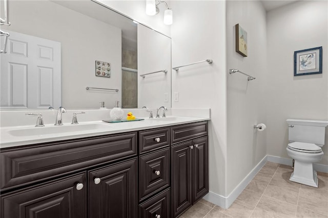full bathroom featuring toilet, tile patterned flooring, double vanity, and baseboards