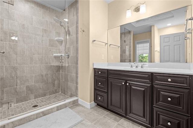 full bath featuring a stall shower, tile patterned flooring, vanity, and baseboards