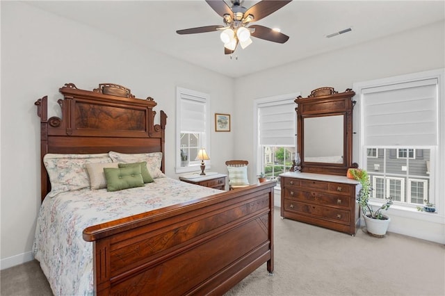 bedroom with light colored carpet, baseboards, and ceiling fan