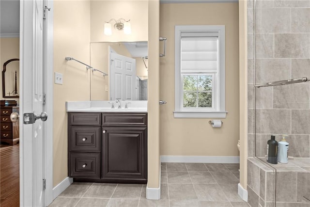 full bath with baseboards, vanity, and tile patterned flooring