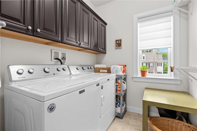 laundry room featuring washing machine and dryer, cabinet space, baseboards, and light tile patterned floors