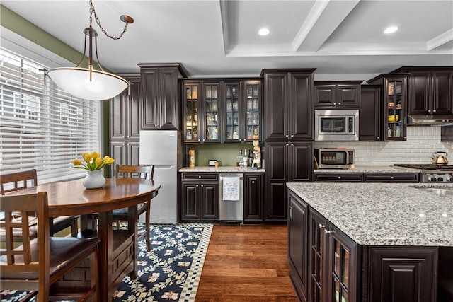 kitchen with appliances with stainless steel finishes, backsplash, dark wood-style flooring, recessed lighting, and decorative light fixtures