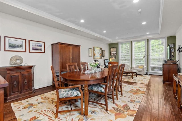 dining room featuring a tray ceiling, recessed lighting, hardwood / wood-style flooring, and baseboards