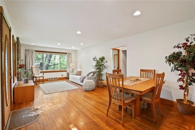 dining space with hardwood / wood-style floors, recessed lighting, and baseboards