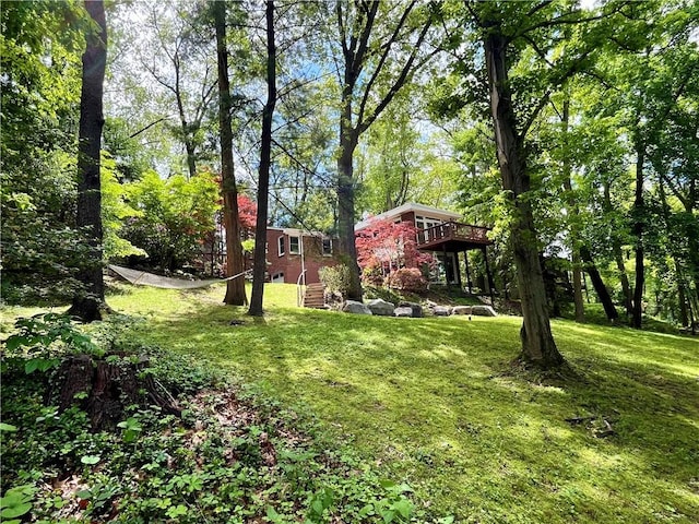 view of grassy yard featuring a wooden deck