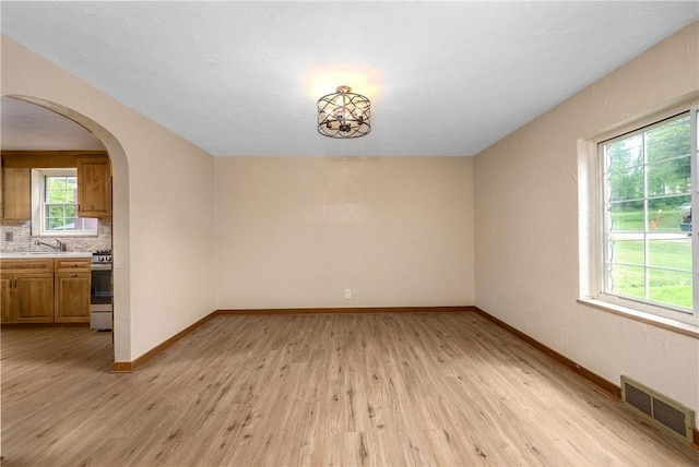 533 Freeport Rd, New Kensington, PA 15068 - spare room featuring light wood-type flooring, baseboards, arched walkways, and a sink