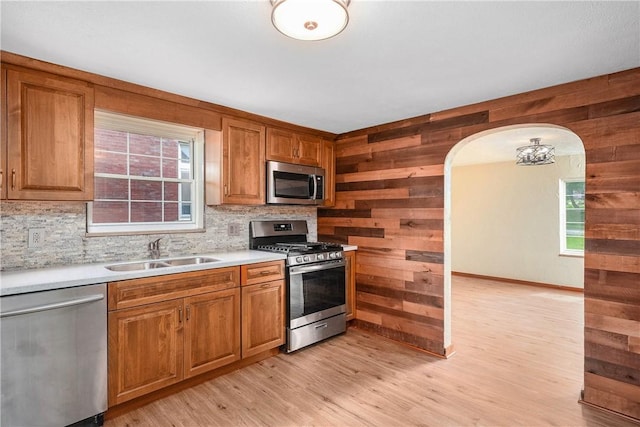 533 Freeport Rd, New Kensington, PA 15068 - kitchen with appliances with stainless steel finishes, a sink, wood walls, arched walkways, and backsplash