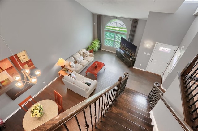 living area with wood finished floors, stairs, and baseboards