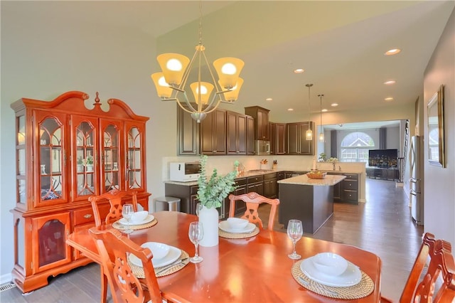 dining room with a chandelier, recessed lighting, and dark wood finished floors