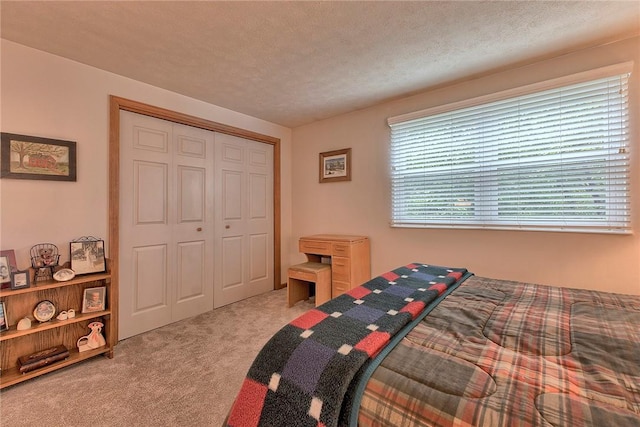 carpeted bedroom with a closet and a textured ceiling