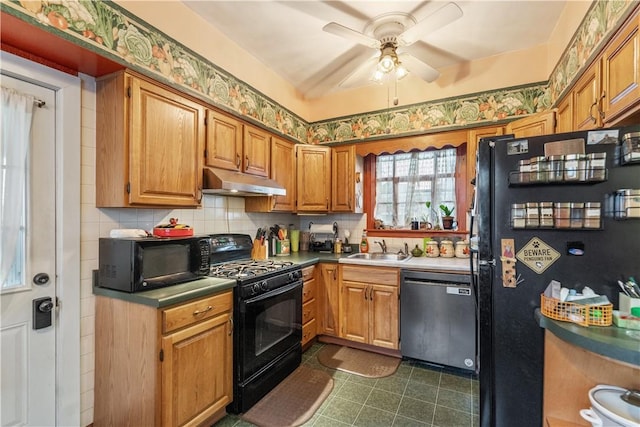 kitchen with black appliances, under cabinet range hood, a sink, a ceiling fan, and tasteful backsplash