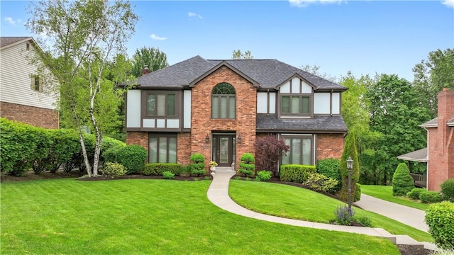 304 Diana Dr, Robinson Twp Nwa, PA 15136 - tudor home with brick siding, a front yard, a shingled roof, and a chimney