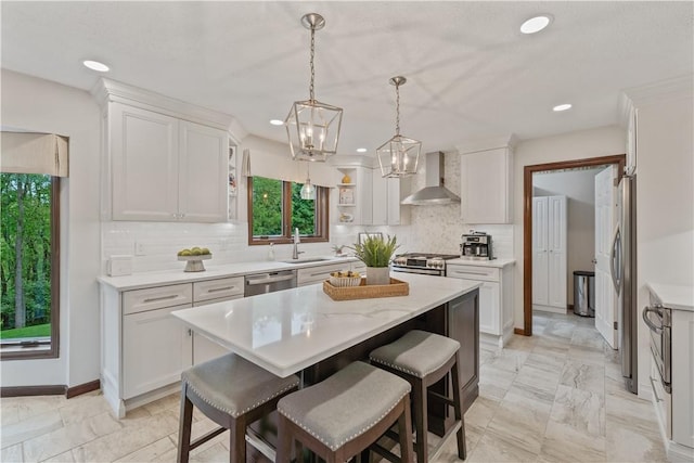 304 Diana Dr, Robinson Twp Nwa, PA 15136 - kitchen featuring wall chimney range hood, a sink, stainless steel appliances, a center island, and white cabinetry