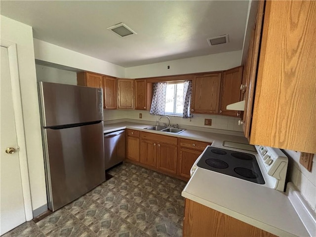 6103 Brownsville Rd, South Park, PA 15236 - kitchen with stainless steel appliances, under cabinet range hood, a sink, brown cabinets, and light countertops