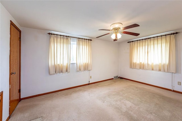 unfurnished room with healthy amount of natural light, a ceiling fan, and carpet flooring