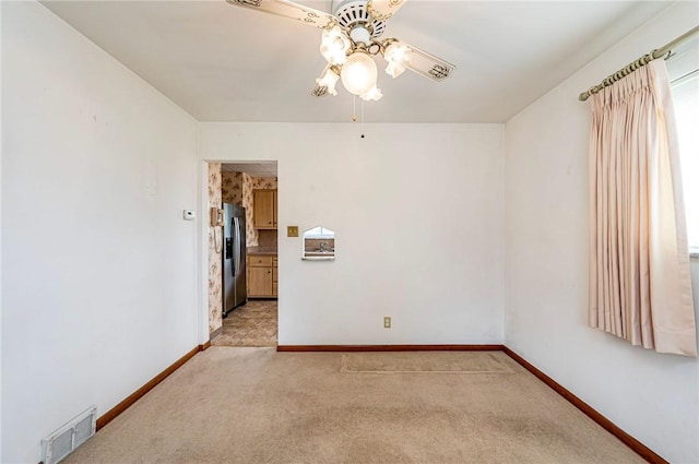 unfurnished room with a ceiling fan, baseboards, and light colored carpet