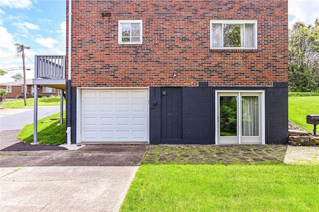 view of front of home featuring an attached garage, brick siding, a front yard, and concrete driveway