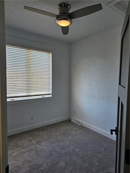 801 Wimbledon Dr, Mount Pleasant Twp Wml, PA 15666 - empty room with healthy amount of natural light, ceiling fan, dark carpet, and baseboards
