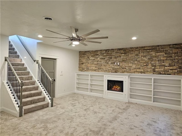801 Wimbledon Dr, Mount Pleasant Twp Wml, PA 15666 - unfurnished living room with ceiling fan, stairs, a glass covered fireplace, carpet, and baseboards