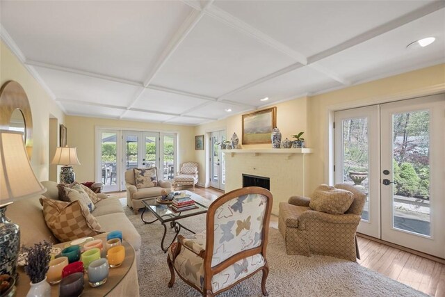 living area featuring french doors, wood-type flooring, coffered ceiling, a brick fireplace, and recessed lighting