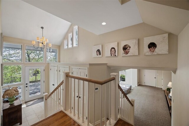 staircase featuring a chandelier and high vaulted ceiling