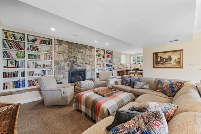 carpeted living area with recessed lighting, a fireplace, and built in shelves
