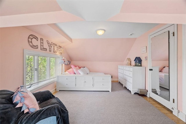 bedroom with vaulted ceiling and light wood-style flooring