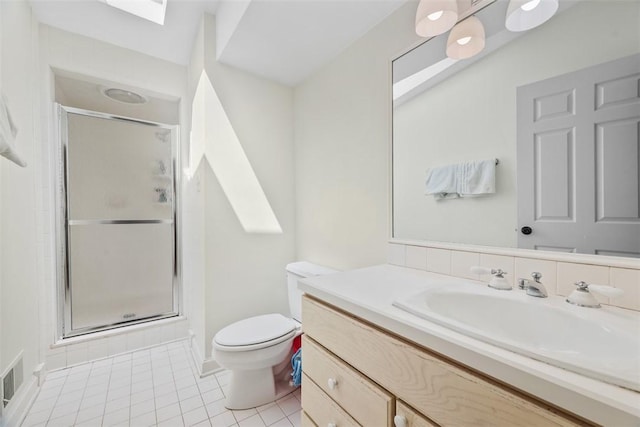 bathroom with tile patterned flooring, a stall shower, toilet, and vanity
