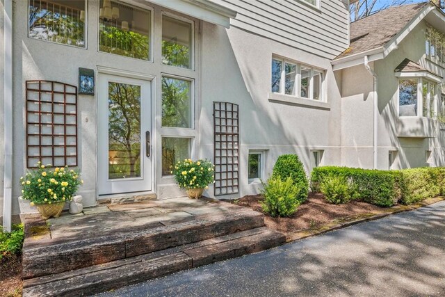 doorway to property featuring stucco siding