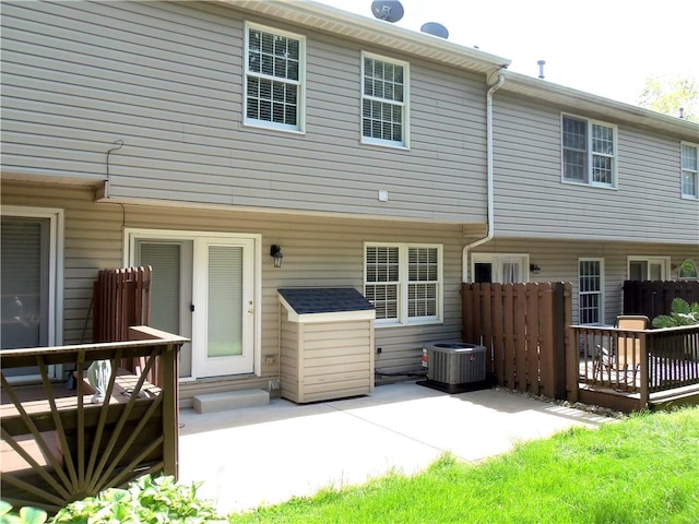 rear view of property featuring cooling unit, a deck, fence, and a patio
