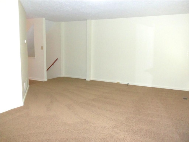 unfurnished room with light colored carpet and baseboards