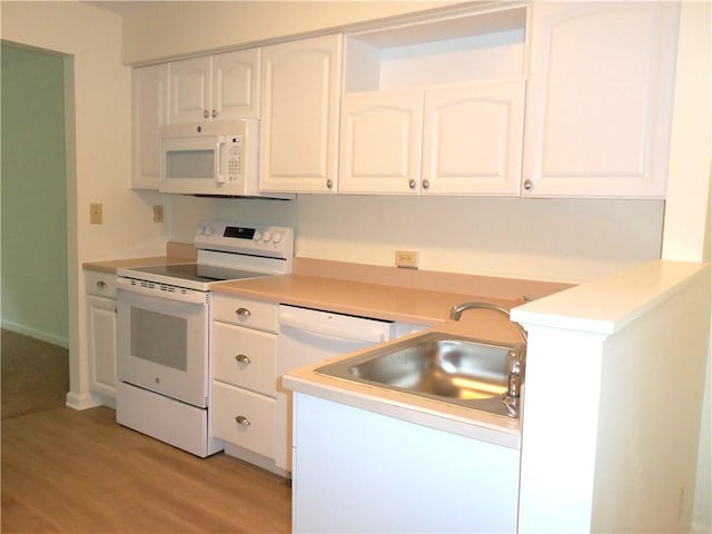 kitchen with white appliances, a sink, white cabinetry, light wood-style flooring, and light countertops