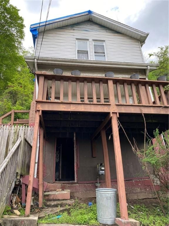 back of property featuring a wooden deck and fence