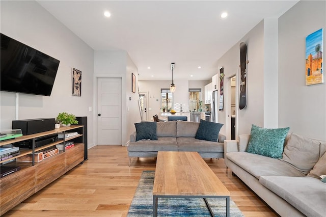 living area with light wood-style flooring and recessed lighting