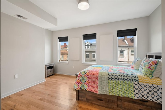 bedroom featuring light wood finished floors and baseboards