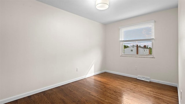 empty room with baseboards and wood finished floors