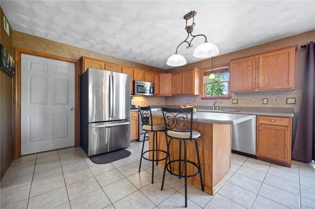 kitchen with stainless steel appliances, light tile patterned floors, tasteful backsplash, a kitchen bar, and hanging light fixtures