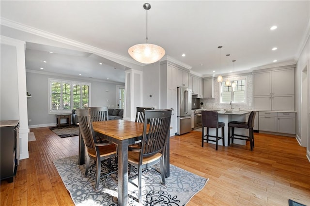 dining area with recessed lighting, light wood-style floors, crown molding, and baseboards