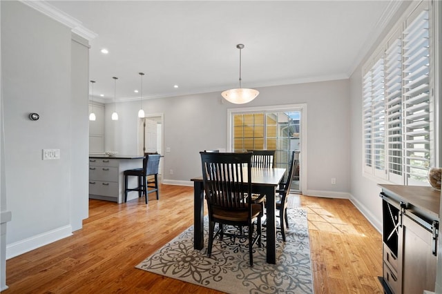 dining area with baseboards, light wood-style flooring, crown molding, and recessed lighting