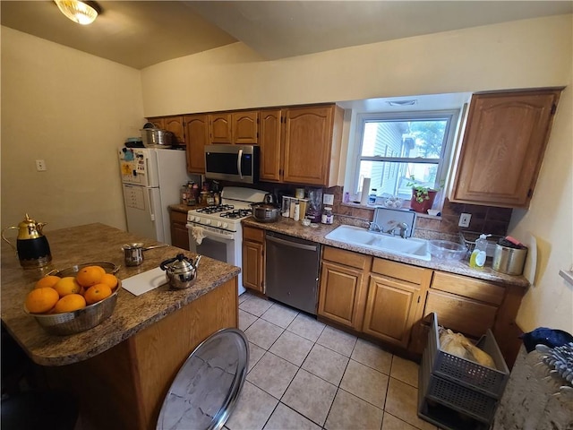 743 Taylor Ave, Avalon, PA 15202 - kitchen with appliances with stainless steel finishes, a sink, light tile patterned floors, backsplash, and brown cabinets