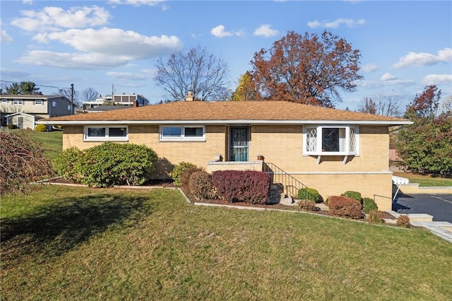 ranch-style house with brick siding and a front yard