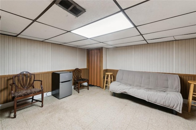 living area with tile patterned floors and a drop ceiling
