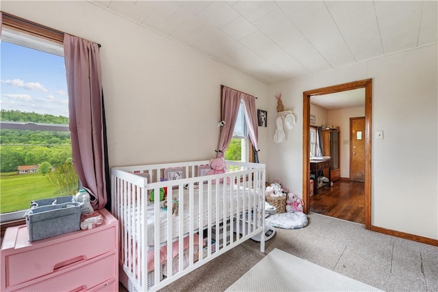 bedroom with carpet floors and a nursery area