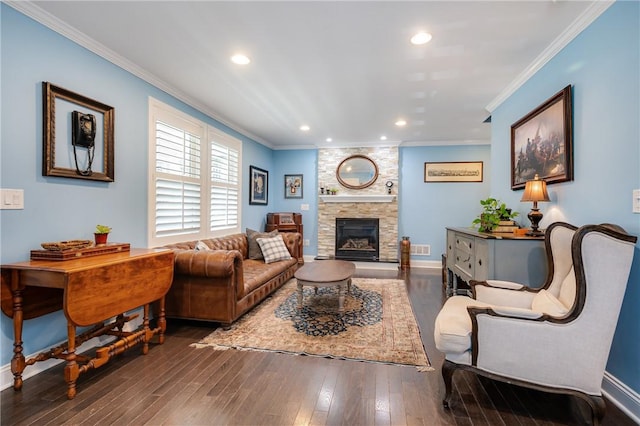 living area with crown molding, a stone fireplace, wood finished floors, baseboards, and recessed lighting