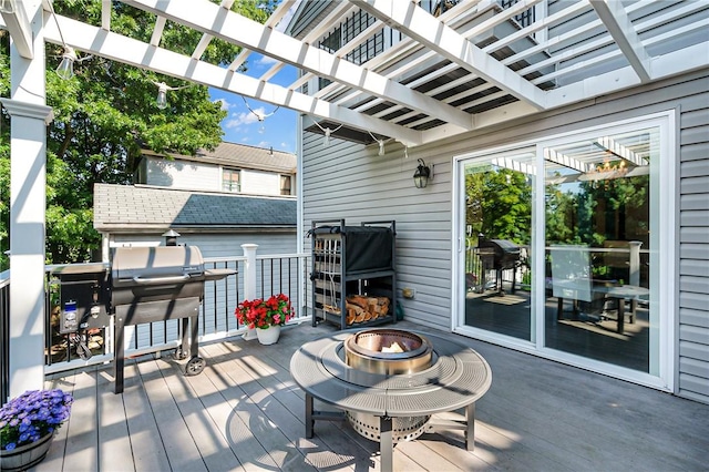 deck featuring a fire pit, a pergola, outdoor dining area, and area for grilling